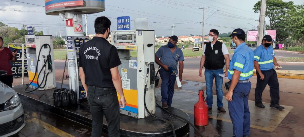Frentista de posto enche suporte com gasolina para fiscais do Procon. (Foto: Procon MS)